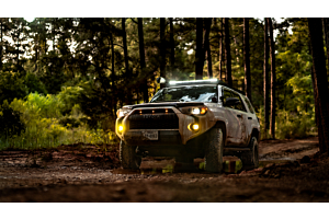 Lifted Toyota 4Runner offroading in the mountains on a sunny day. 
