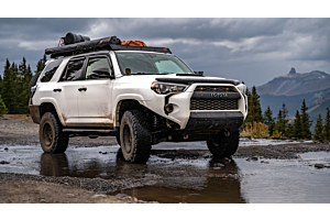 Lifted Toyota 4runner offroading in the mountains on a sunny day. 