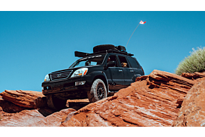 Lifted Toyota Tacoma offroading in the mountains on a sunny day. 