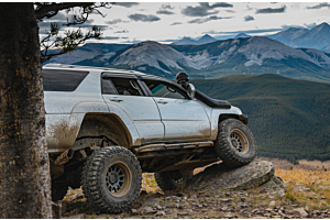 Lifted Toyota 4Runner offroading in the mountains on a sunny day. 