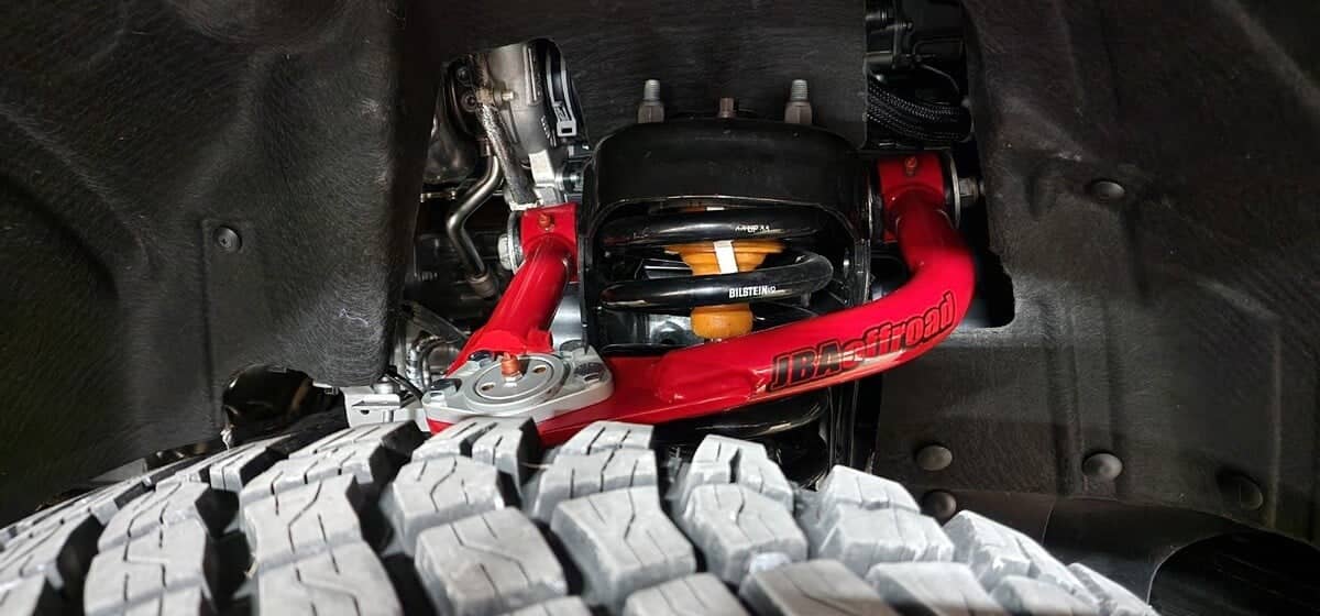 Full view of a red JBA Offroad upper control arm.