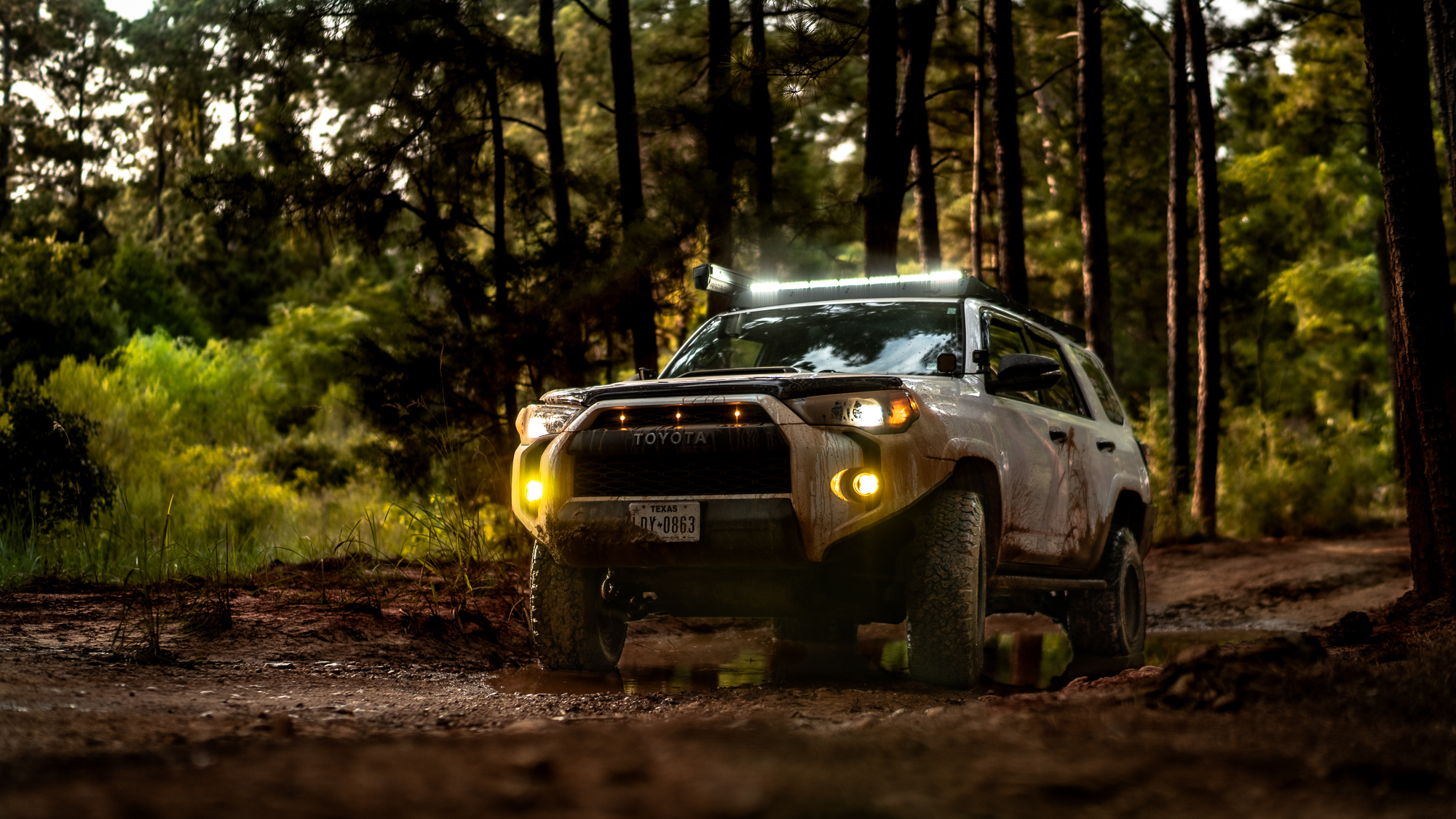 Lifted Toyota 4Runner offroading in the mountains on a sunny day. 