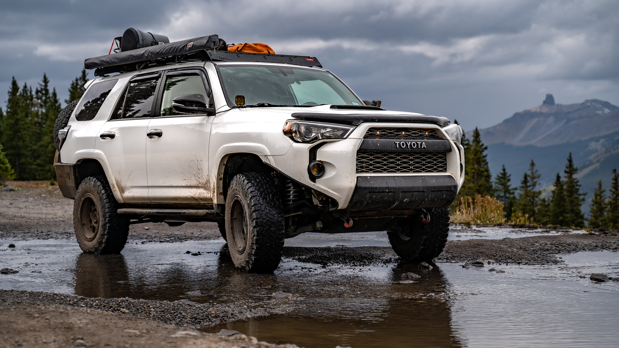 Lifted Toyota 4runner offroading in the mountains on a sunny day. 