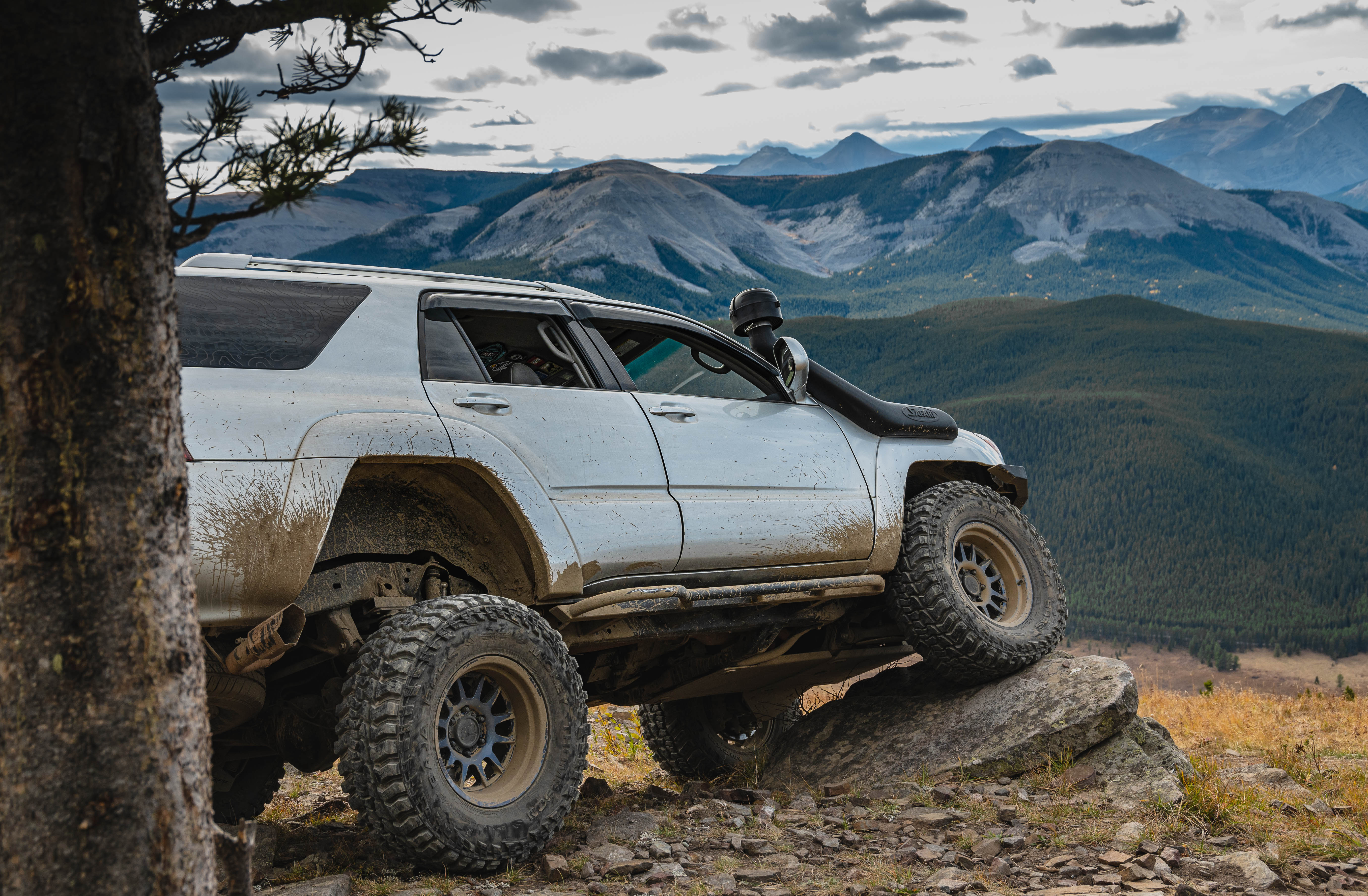Lifted Toyota 4Runner offroading in the mountains on a sunny day. 