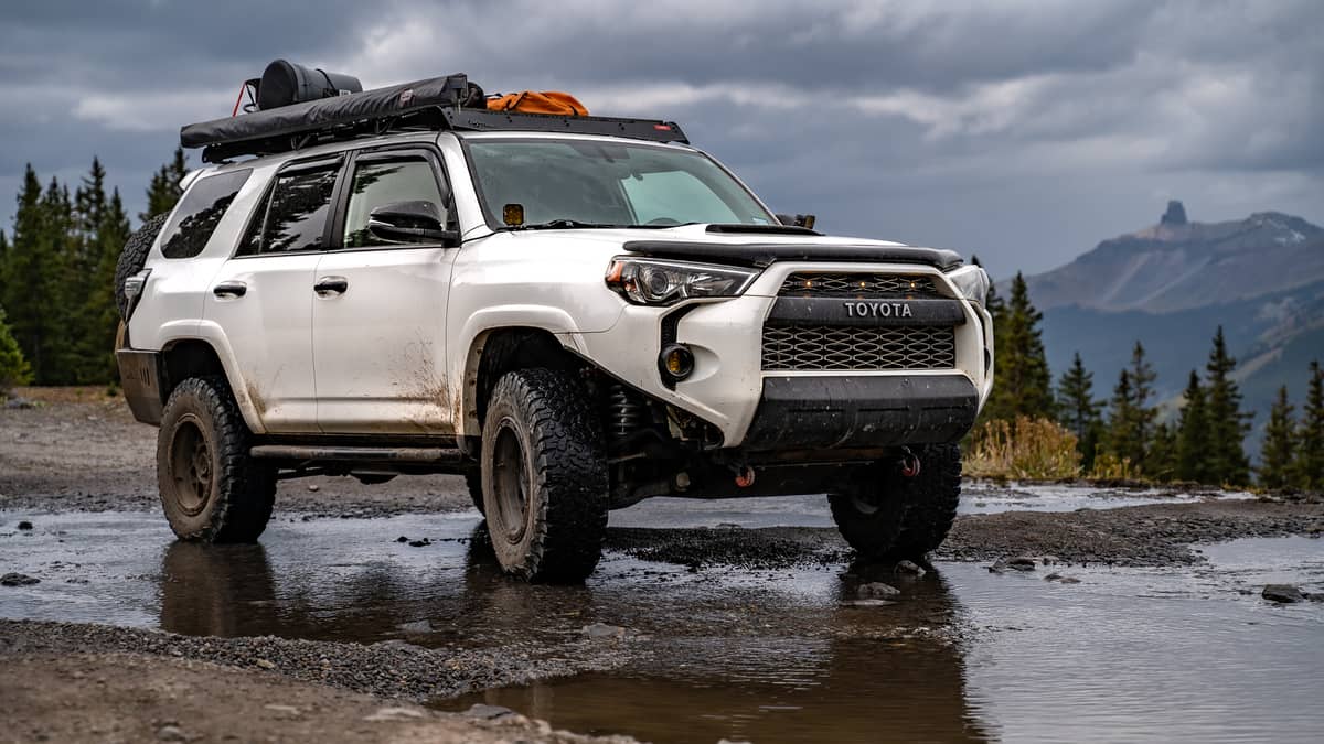 Lifted Toyota 4runner offroading in the mountains on a sunny day. 