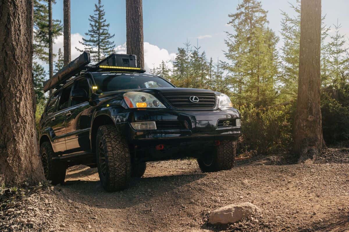 Lifted Toyota Tacoma offroading in the mountains on a sunny day. 